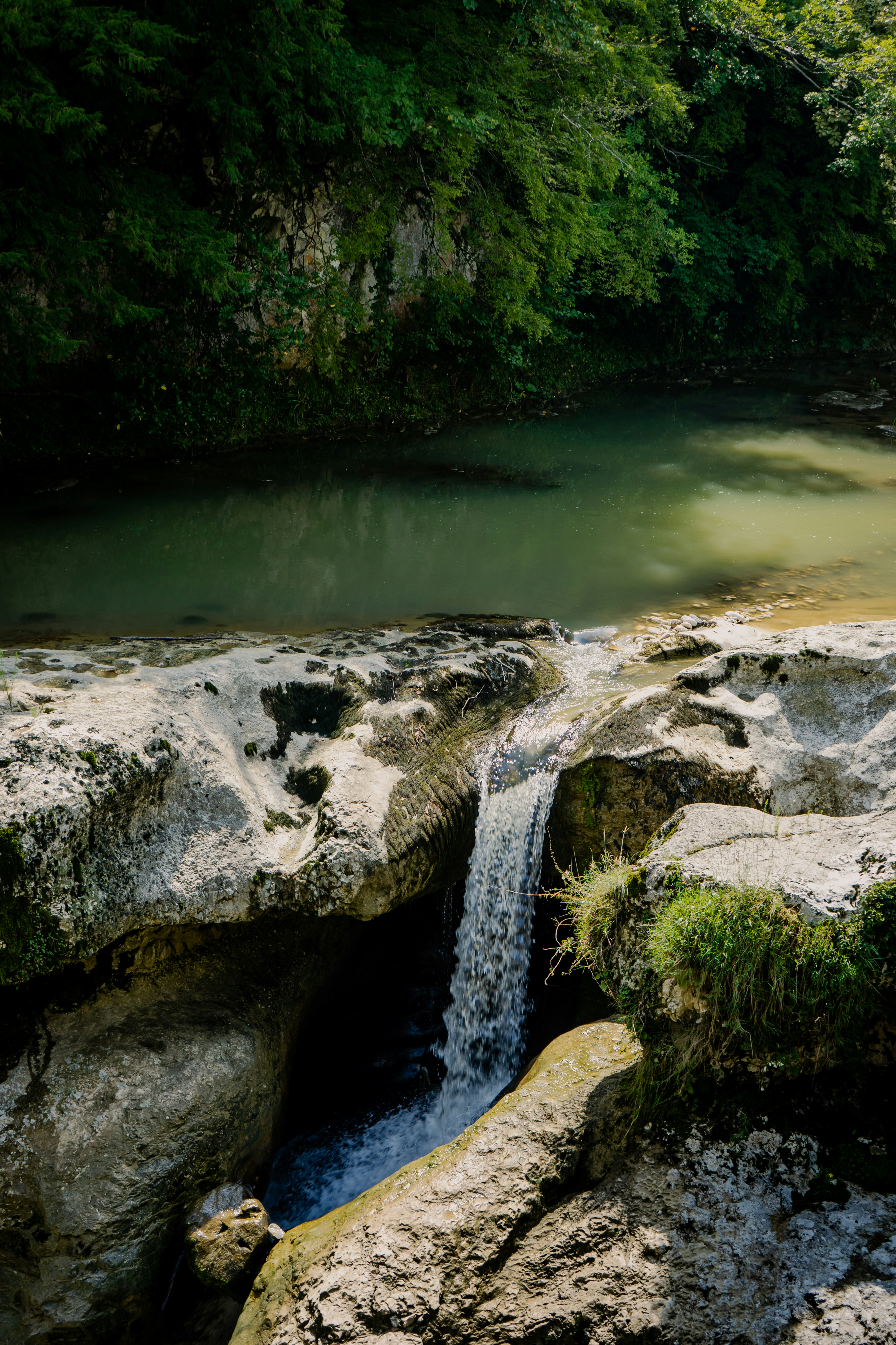 gray rock formation near green body of water during daytime